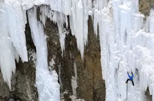 A man climbs up an artificially made wall of ice near the Swiss mountain resort of