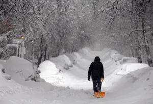 Weather Prints: A man drags a shovel up Beacon Hill during a severe winter snow storm in Boston
