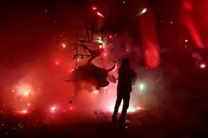 : Man enjoys the fireworks exploding from a traditional bull figure known as El Torito in