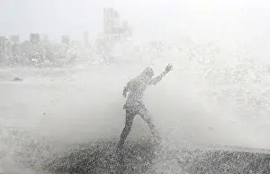 Weather Prints: A man loses his balance as he gets drenched by a large wave during high tide at a