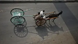 A man pulls a newly purchased cart while travelling in another horse-cart through