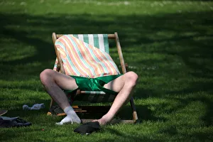 Weather Prints: A man relaxes in the sunshine in St James Park in central London
