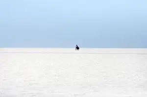 A man rides a bicycle on the surface of the worlds largest salt flat, the Salar de Uyuni