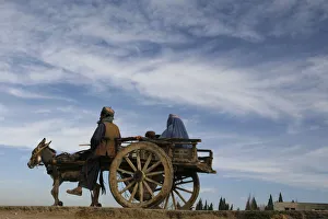 A man rides a cart led by a donkey through the outskirts of Quetta