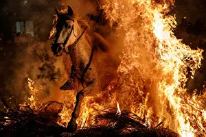 Festival Prints: A man rides a horse through flames during the annual Luminarias celebration on the eve