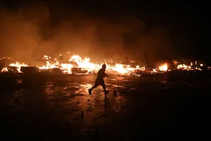 Haiti Prints: A man runs next to fire at a market in Port-au-Prince