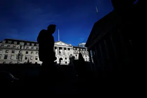 A man is silhouetted as he walks past the Bank of England in the City of London