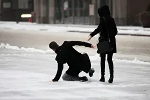 A man slips on ice covered sidewalk as freezing rain falls in Toronto