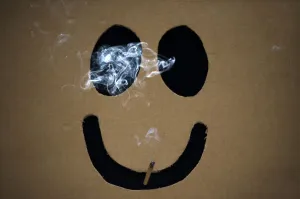 Images Dated 2011 May: A man smokes a marijuana joint inside a box with a happy face cut out before The Global