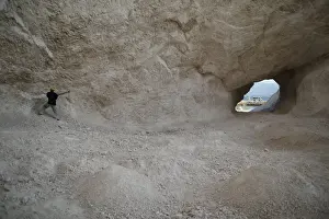 Haiti Prints: A man uses a pick to break rocks and get sand in a sand mine on the outskirts of Fond