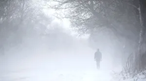 Britain Prints: A man walks along the A53 Buxton Road which is closed due to heavy snow fall, near Leek