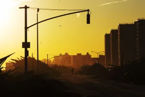 A man walks down Shore Front Parkway surrounded by debris pushed onto the streets by A man walks down Shore Front Parkway surrounded by debris pushed onto the streets by