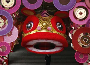 A man walks down the stairs of a shopping mall, decorated to celebrate the upcoming Lunar New Year
