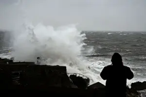 Weather Prints: A man watches a large wave break over the Forty Foot diving area as Storm Emma makes