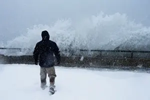 Prints of A man watches as ocean waves overtop the seawall during a winter snow storm in the Boston suburb of Lynn, Massachusetts, U.S. January 4, 2018. REUTERS/Brian Snyder USA Prints: A man watches as ocean waves overtop the seawall during a winter snow storm in the Boston