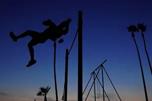 Dailylife Prints: A man works in his high bar skills at sunset in the Venice Beach area of Los Angeles