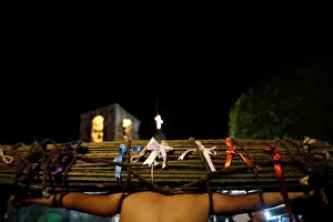 Religion Prints: A masked penitent carries thorny boughs with ribbons on his shoulders during a procession
