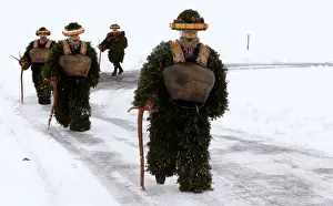 Men dressed as Chlaeuse walk during the traditional Sylvesterchlausen near Urnaesch