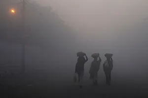 India Prints: Men walk along a street on a foggy morning in the old quarters of Delhi