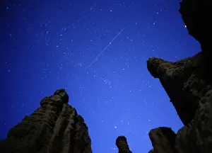 Macedonia Prints: A meteor streaks past stars in the night sky over the village of Kuklici
