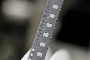 Singapore Prints: Microchips emerge from a machine onto a roll in the clean room at the UTAC plant in
