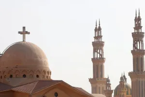 Ramadan Prints: Minarets of a mosque and the cross above a church is seen during the Muslim holy fasting