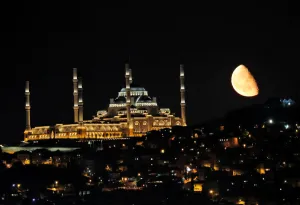 The moon rises over the Grand Camlica Mosque in Istanbul