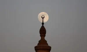 The full Moon rises over a minaret of a mosque during sunset on the 12th day of the The full Moon rises over a minaret of a mosque during sunset on the 12th day of the