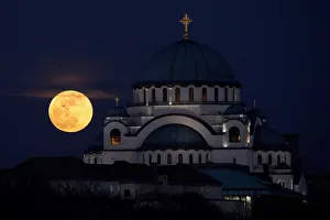 A full moon rises behind St. Sava temple in Belgrade