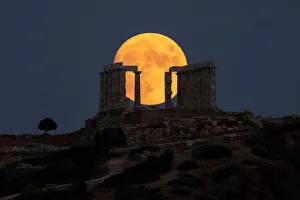 An almost full moon rises over the Temple of Poseidon in Cape Sounion, near Athens An almost full moon rises over the Temple of Poseidon in Cape Sounion, near Athens