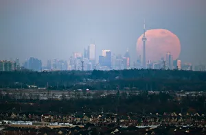 The moon rises over the Toronto city skyline as seen from Milton, Ontario