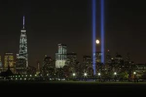 The moon rises between the Tribute in Light illuminated next to One World Trade The moon rises between the Tribute in Light illuminated next to One World Trade