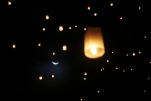 Moonlight Prints: The moon is seen behind lanterns released by survivors, local residents and visitors