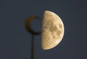 : The moon is seen behind a mosque in the city of Almaty
