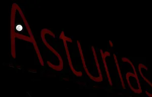 Sighting Prints: A full moon super moon is seen through a luminous sign with the name of the region