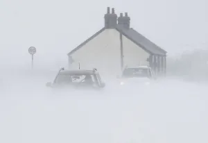 Prints of Motorists drive through snow blown from fields near Buxton in central England March 22, 2013. Heavy snowfalls caused disruption across the country on Friday Britain Prints: Motorists drive through snow blown from fields near Buxton in central England