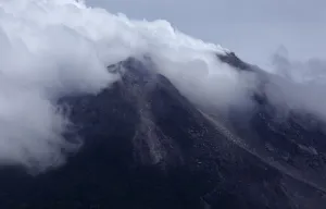 Indonesia Prints: Mount Merapi volcano emits smoke as it is seen from Kinahrejo village near Yogyakarta