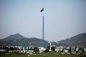 Northkorea Prints: A North Korean flag flutters on top of a tower at the propaganda village of Gijungdong in