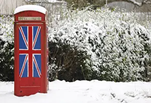 An old telephone box painted with the Union Flag stands out in the snow at Staplefield