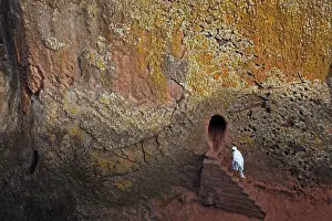 Orthodox Christian walks into one of 11 monolithic rock-cut churches, ahead of Orthodox