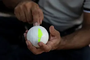 A Pakistani man living in Greece wraps a tennis ball in electrical tape before a