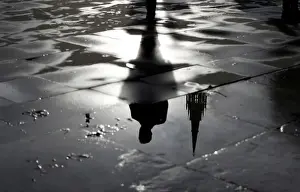 Dailylife Prints: The Palace of Westminster and a man walking are reflected in a puddle in London
