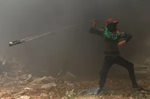 Prints of A Palestinian demonstrator uses a sling to hurl stones at Israeli troops during a protest ahead of the 70th anniversary of Nakba, near the Jewish settlement of Beit El, near Ramallah Israel Prints: Palestinian demonstrator uses a sling to hurl stones at Israeli troops during a protest