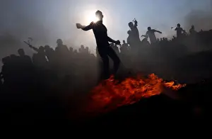Prints of Palestinian demonstrators hurl stones at Israeli troops during a protest demanding the right to return to their homeland, at the border fence between Israel and Gaza Israel Prints: Palestinian demonstrators hurl stones at Israeli troops during a protest at the border