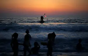 Beach Prints: Palestinians ride a boat in the Mediterranean Sea in the northern Gaza Strip