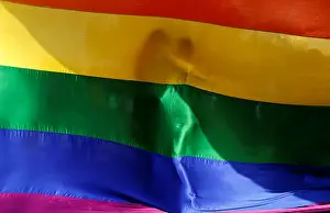 Participants hug each other behind a rainbow flag during a vigil in memory of the victims