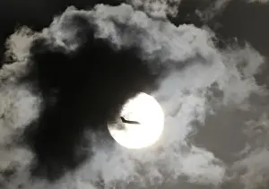 India Prints: A passenger aircraft is silhouetted against the rising sun after taking off from New