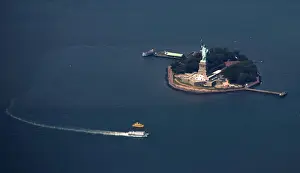 A passenger ferry leaves the The Statue of Liberty and Liberty Island seen from this