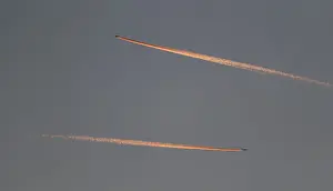 Airline Prints: Passenger planes leave behind contrails as they fly in the skies over London Luton