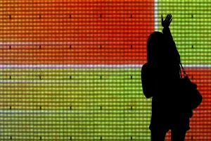 A passer-by touches an electronic screen displayed as part of Christmas decorations